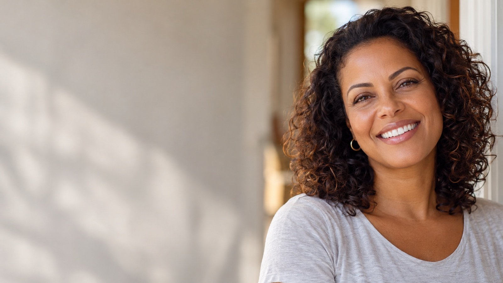 Cena ilustrativa de mulher adulta sorrindo perto de uma porta de casa